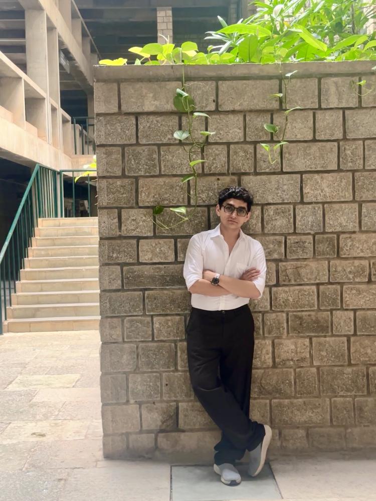 White shirt brick wall wide arms crossed